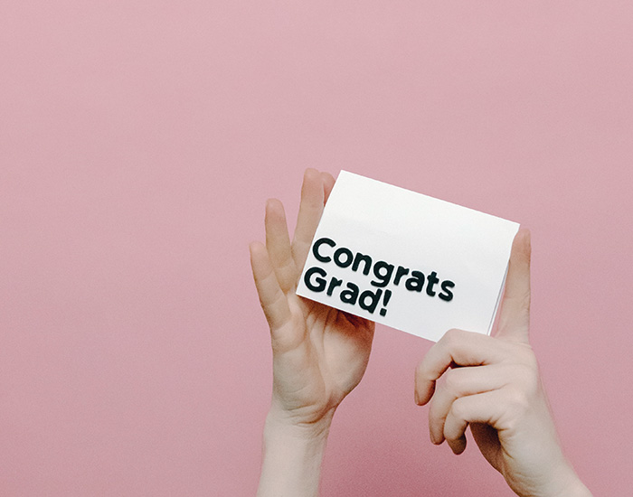 Zwei Hände halten ein Schild hoch mit dem Aufdruck Congrats Grad ©Pexels: Tara Winstead