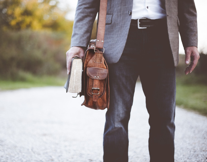 Mann mit Umhängetasche und Buch in der Hand ©Pixabay Lizenz, Pexels