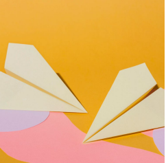 Papierflieger vor orangem Hintergrund ©freepik