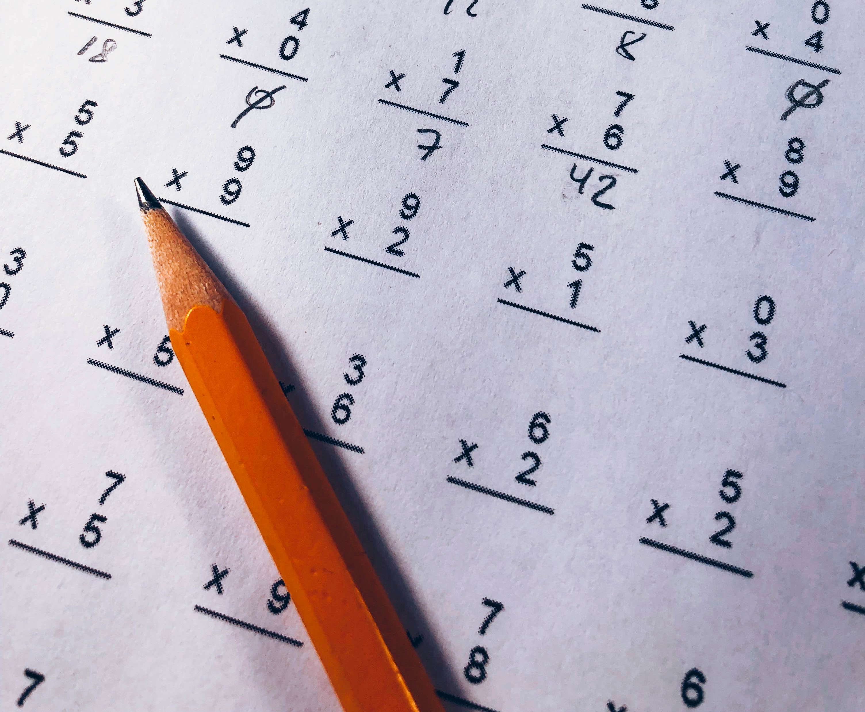 A brown pencil is laying on a paper showing mathematical tasks ©Photo by Chris Liverani on Unsplash