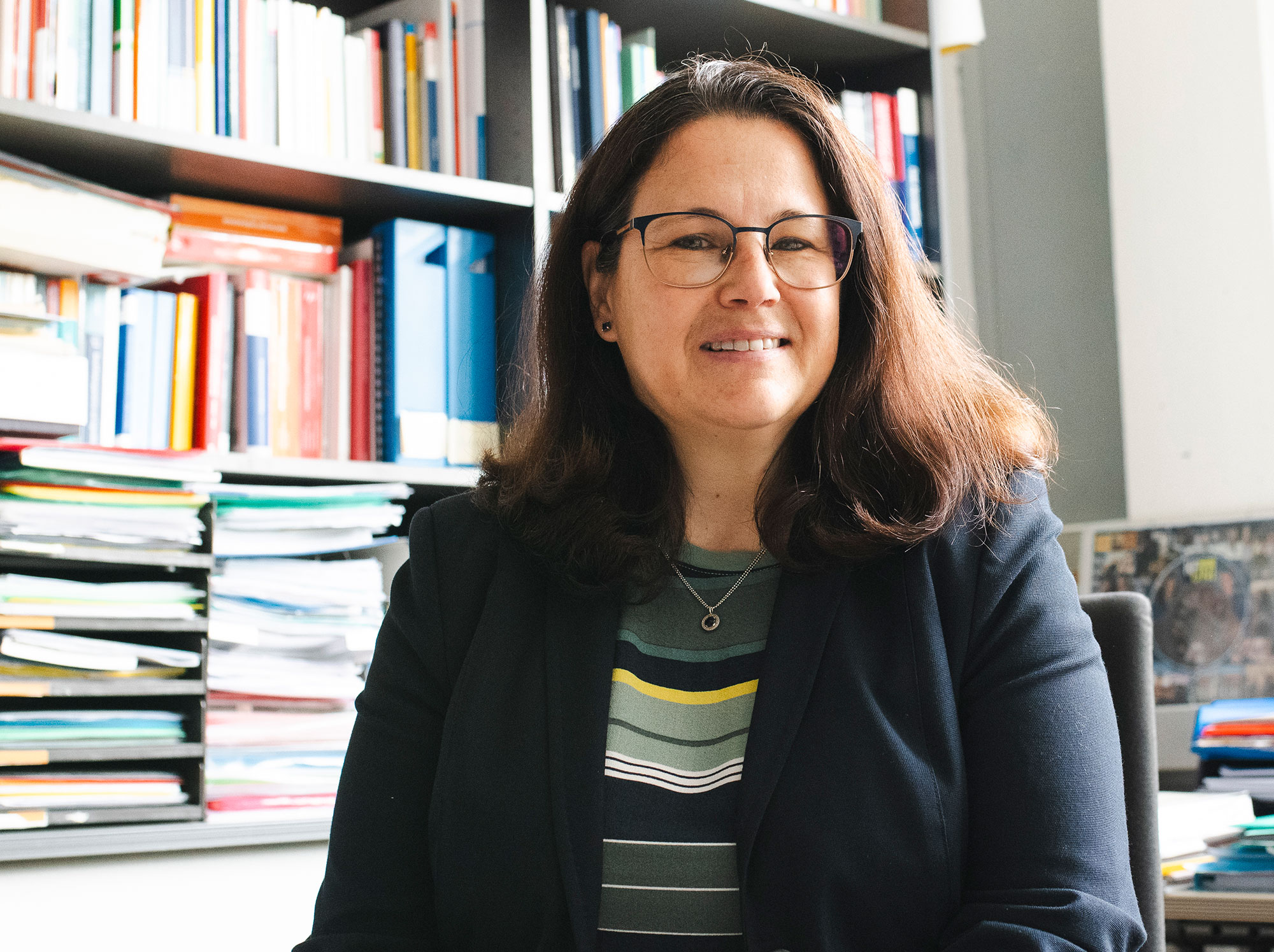 Elisabeth Riebenbauer in ihrem Büro, im Hintergrund volle Bücherregale