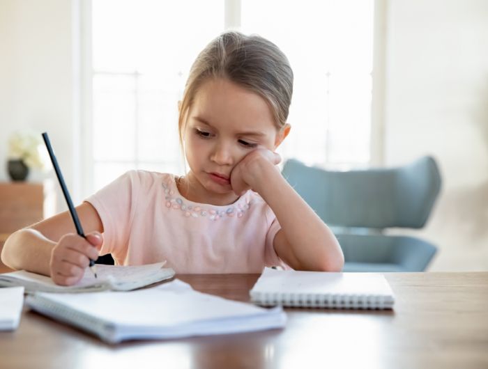 Mädchen an Tisch sitzend ©fizkes / Shutterstock.com