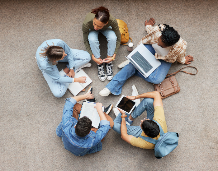 Five people sit in a tight circle on the floor and work together ©Yuri Arcurs peopleimages.com - stock.adobe.com