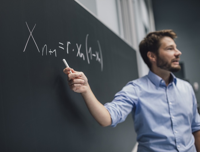 Person mit Kreide in der Hand an einer Tafel, mathematische Gleichung ©Uni Graz/Kanizaj