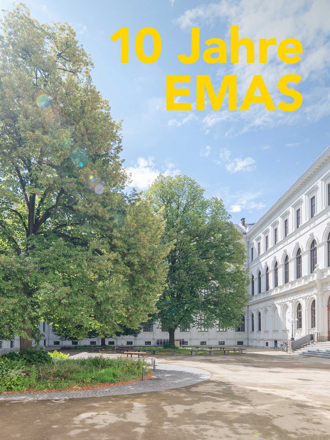 ein sonnendurchfluteter Innenhof mit Bäumen und der Aufschrift: 10 Jahre EMAS 