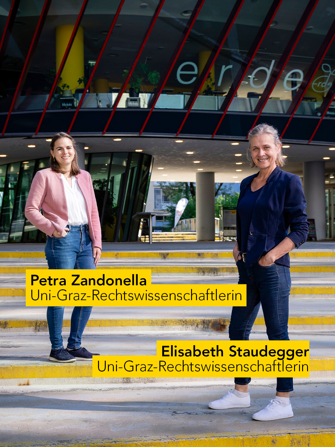 Zwei Frauen stehen auf Stufen leicht versetzt hintereinender. 