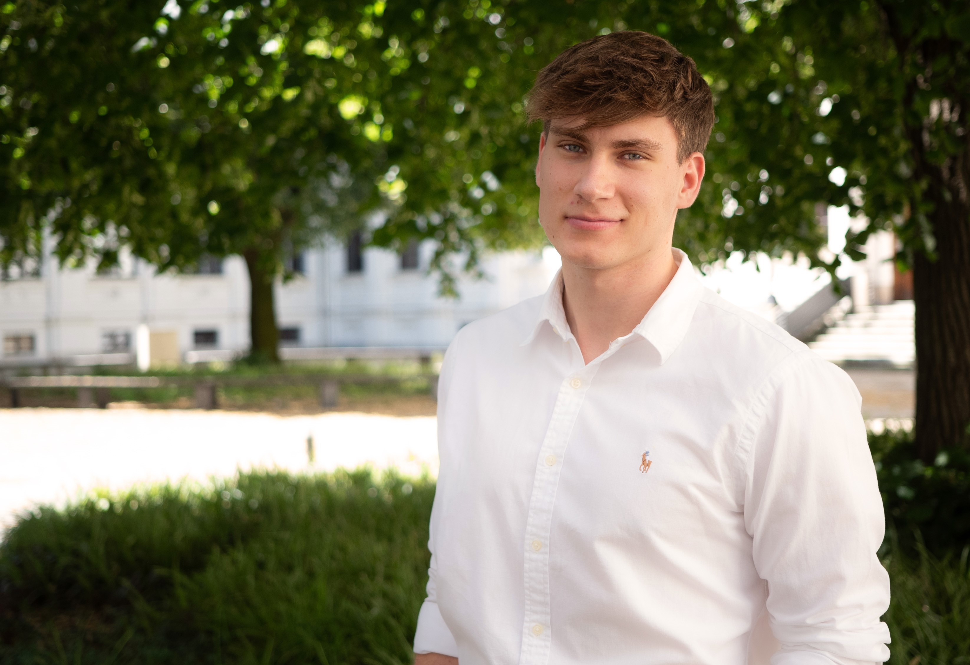 Franz Pucher im Portraitfoto im Innenhof der Hauptgebäude der Universität Graz.