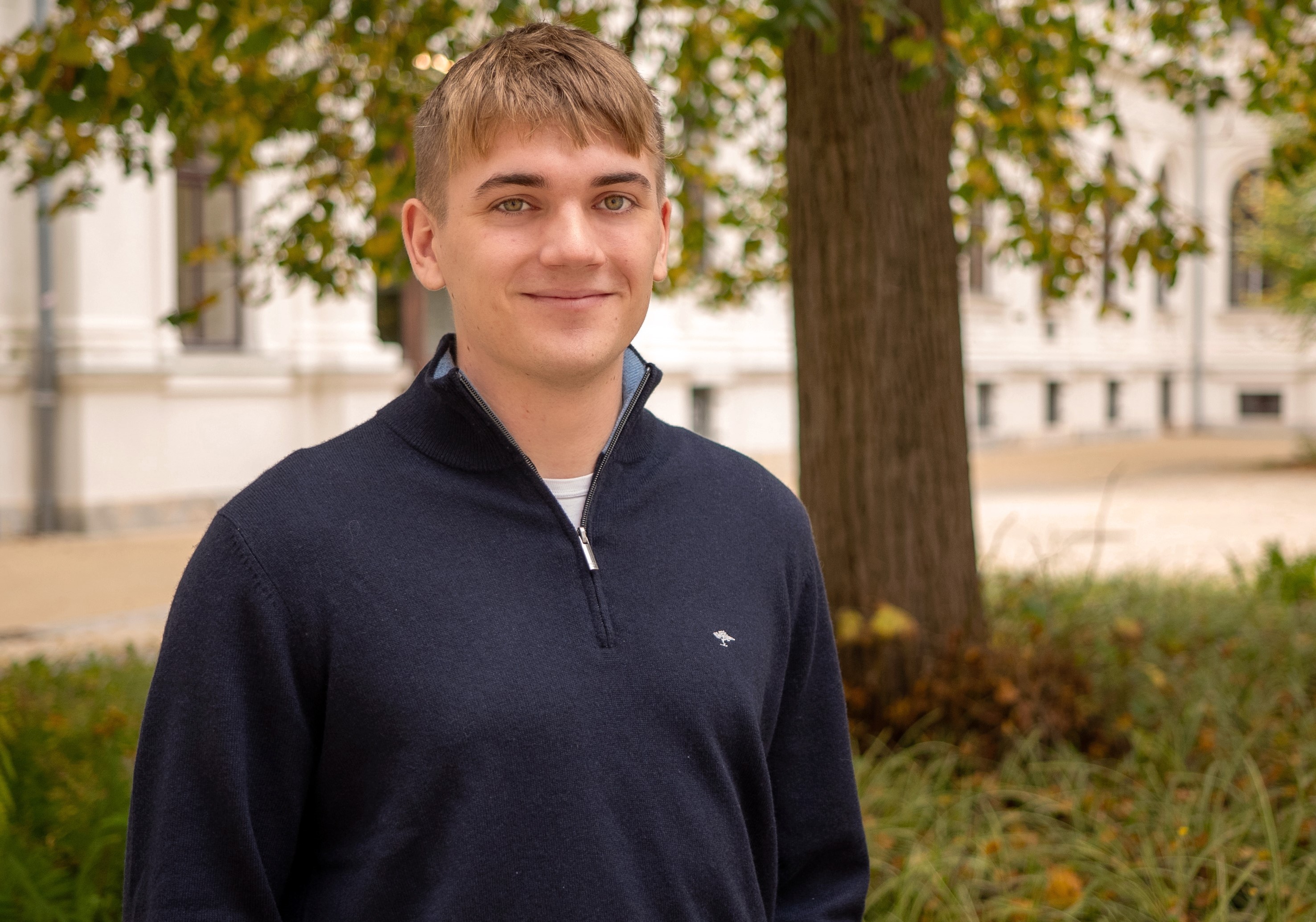 Fabian Wallner im Portraitfoto im Innenhof der Hauptgebäude der Universität Graz.