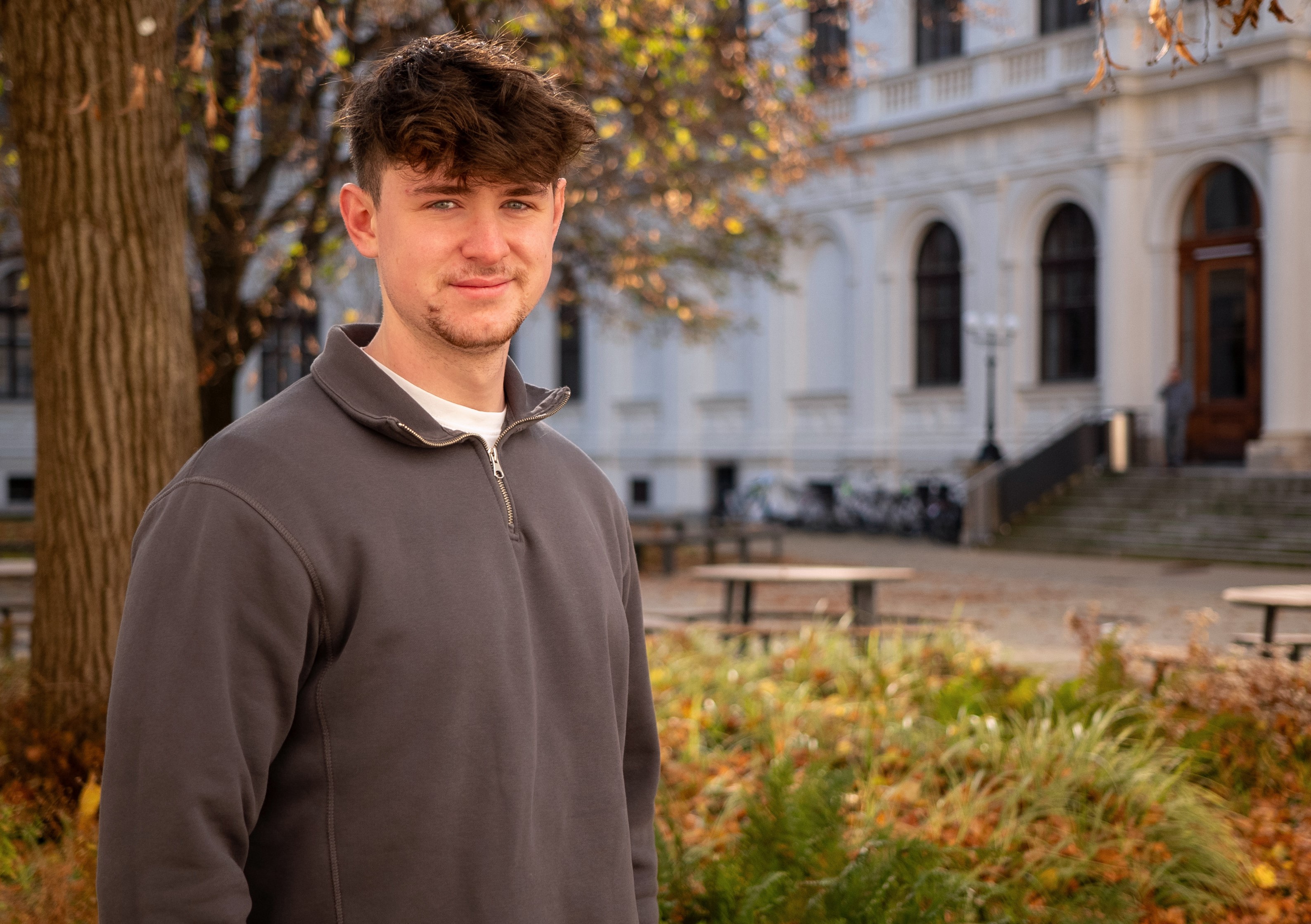 Samuel Tieber im Portraitfoto im Innenhof der Hauptgebäude der Universität Graz.