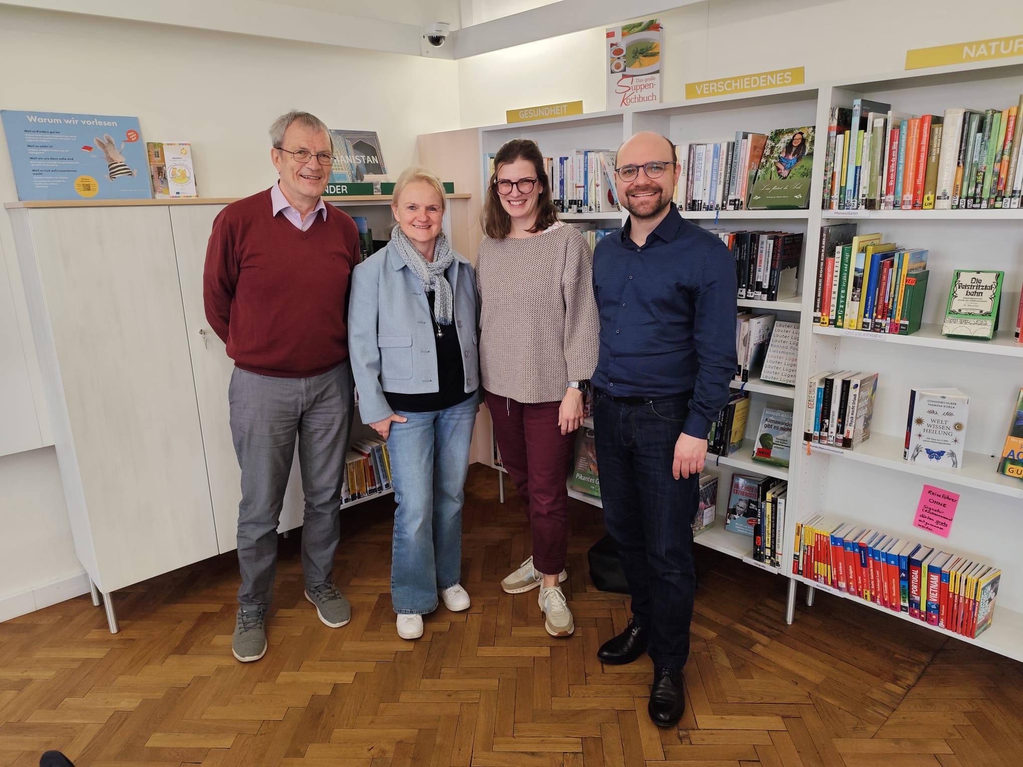 zwei Frauen und zwei Männer stehen vor einem Bücherregal und lächeln ©Uni Graz/Freidorfer