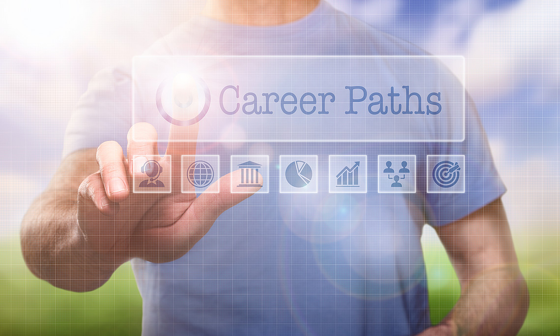 A man in a t-shirt outside selection a Career Paths concept word