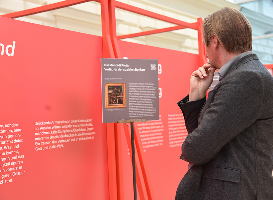 Ein mann von hinten fotografiert schaut sich eine austellung an 