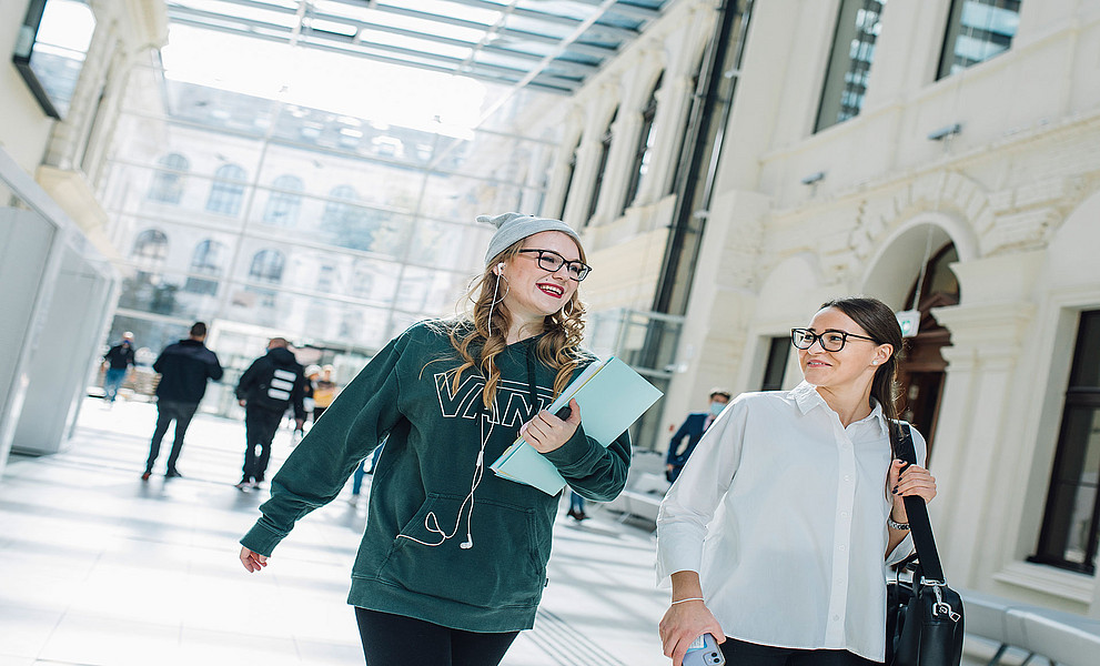 zwei Studentinnen im Bibliotheksfoyer