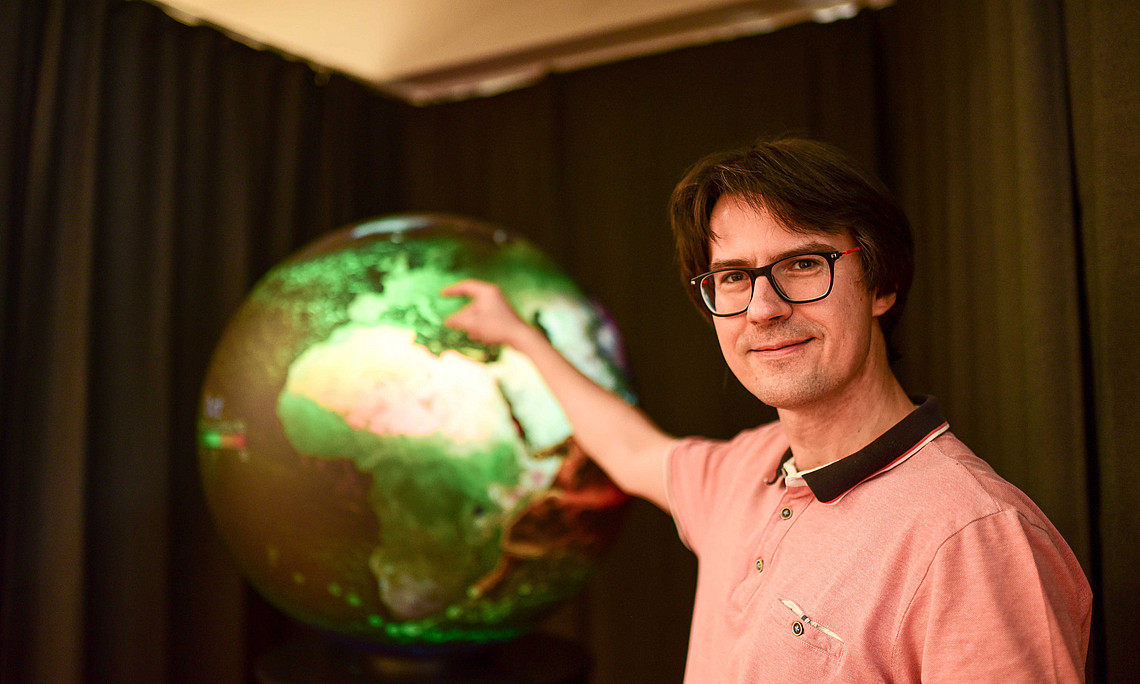 Dort ist Österreich: Martin Mergili zeigt auf die Darstellung am digitalen Globus. Fotos: Uni Graz/Tzivanopoulos
