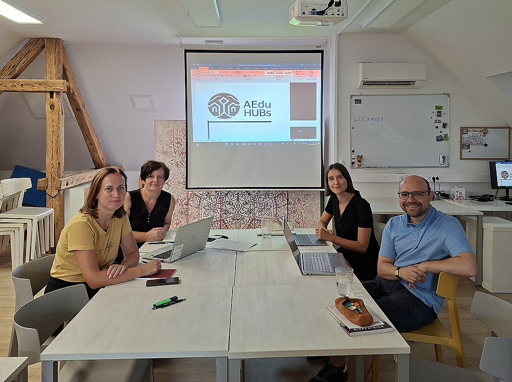 drei Frauen und ein Mann, die um einen Tisch sitzen und an Laptops arbeiten ©Projektteam AEduHUBs