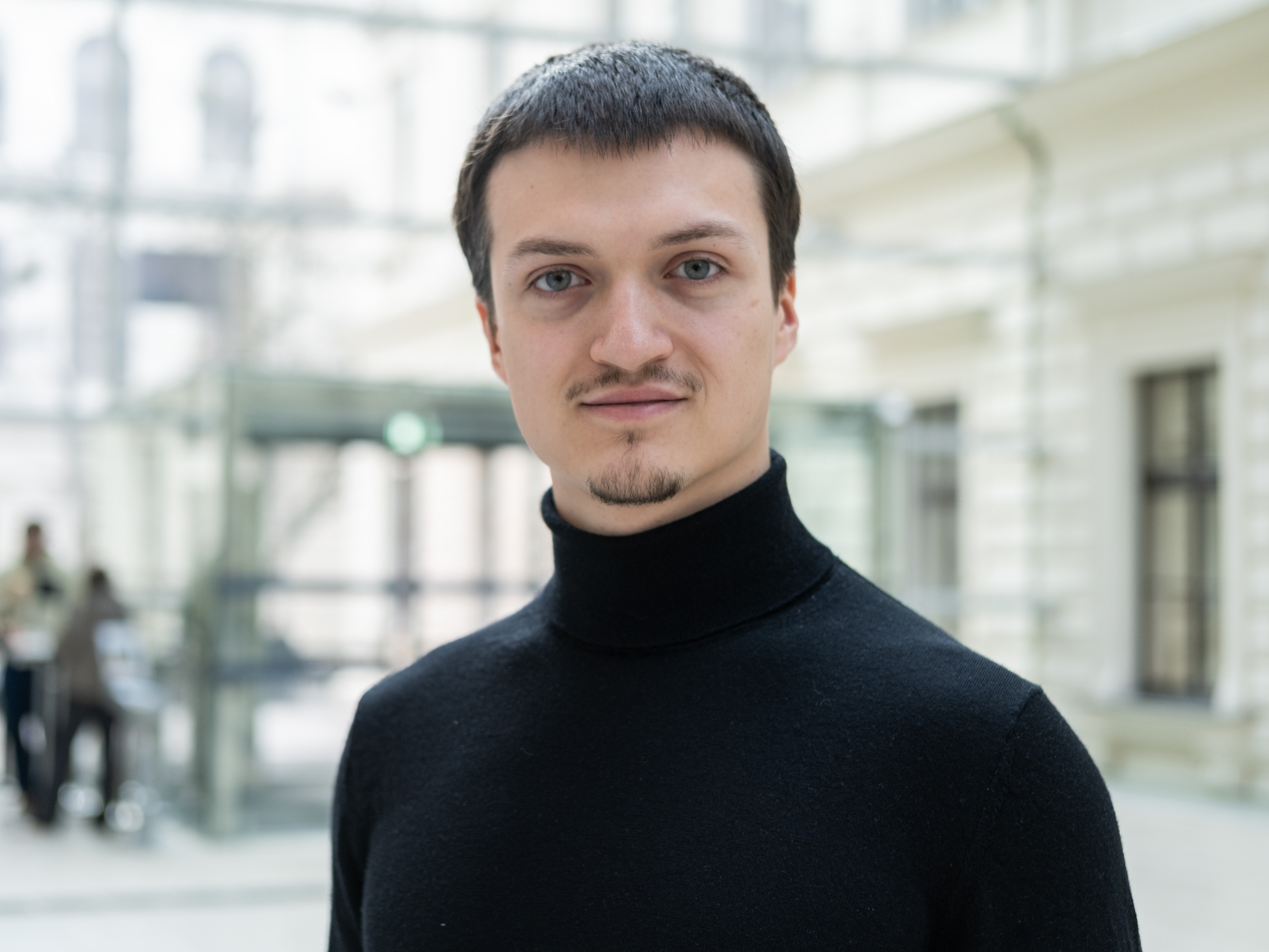 Herr Kontriner im schwarzen Pullover im Foyer der Universitätsbibliothek