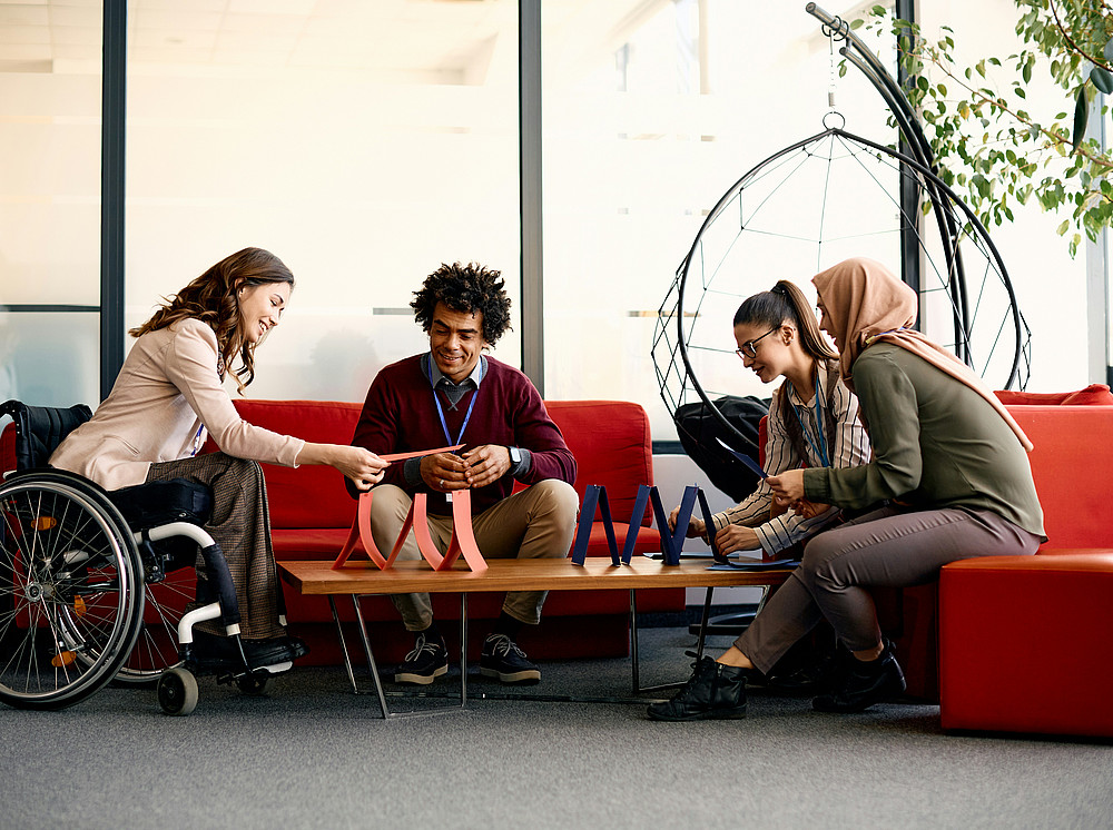 diverse-geschaftsleute-die-eine-pause-bei-der-arbeit-geniessen-wahrend-sie-gemeinsam-ein-kartenhaus-bauen ©Getty Images Unsplash