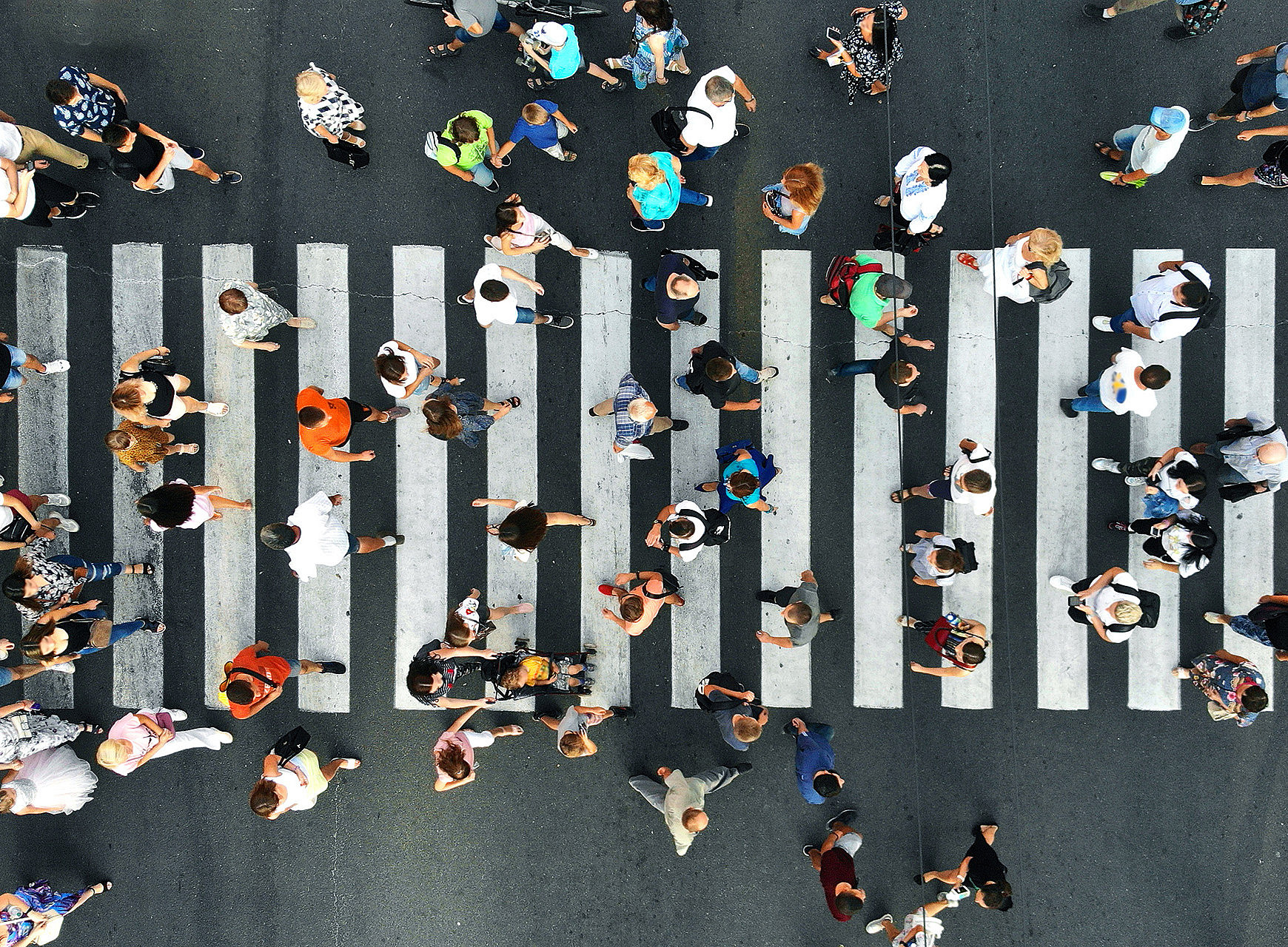 Vogelperspektive auf Fußgänger:innen auf einem Zebrastreifen 