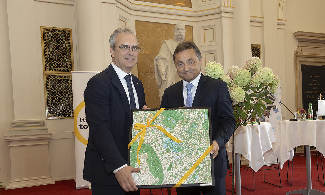 Zwei Männer in Anzug mit einem Bild in der Hand