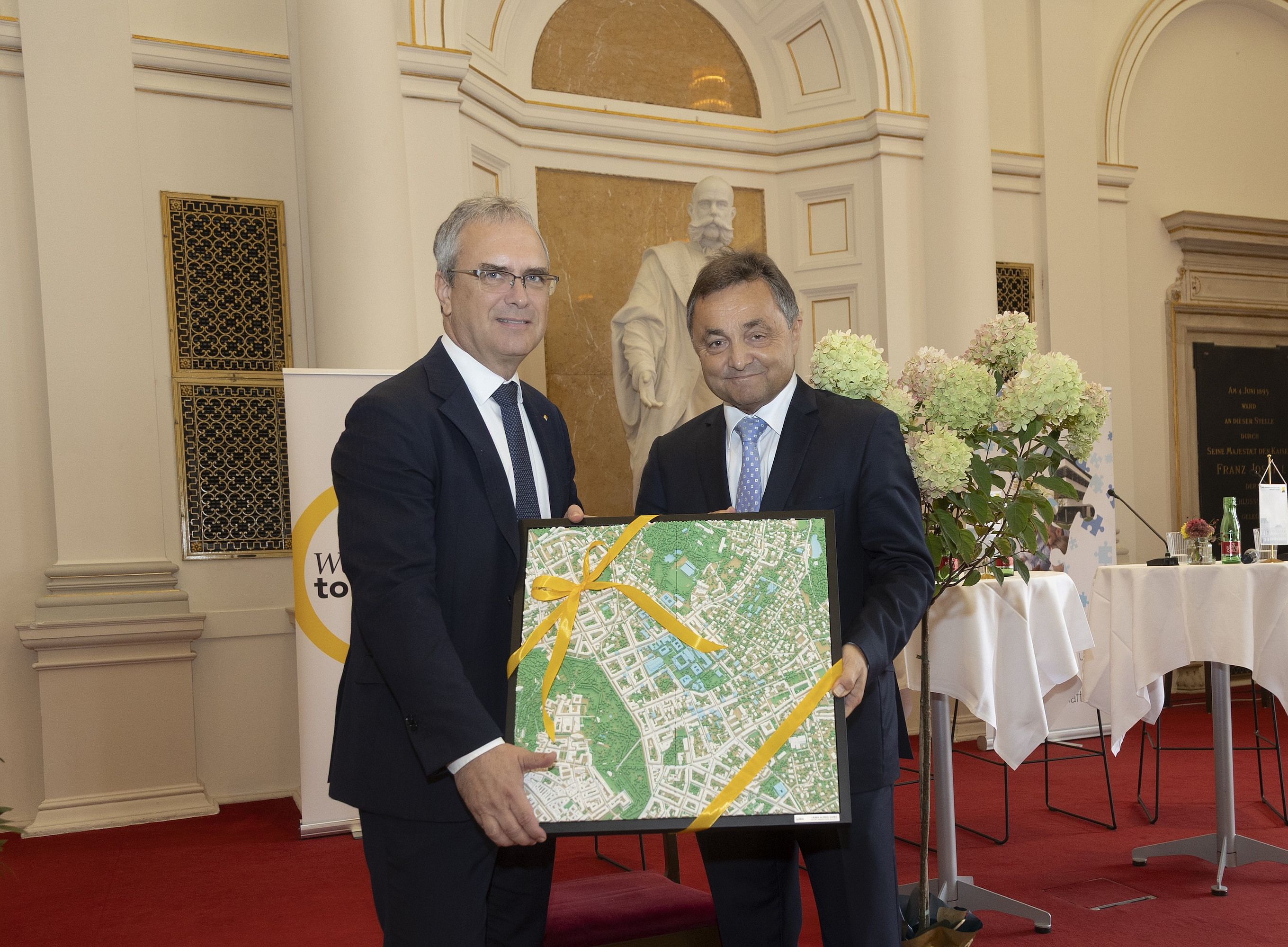 Zwei Männer in Anzug mit einem Bild in der Hand ©Fotostudio Gasser