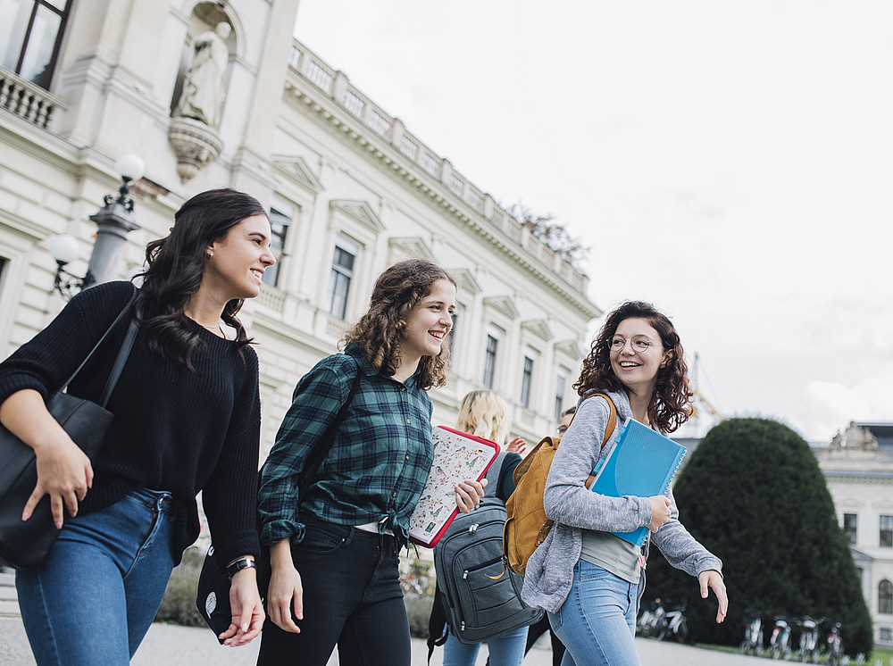 Three women walk on the campus of the University of Graz and symbolize the Center for Active Mobility ©Uni Graz / Kanizaj