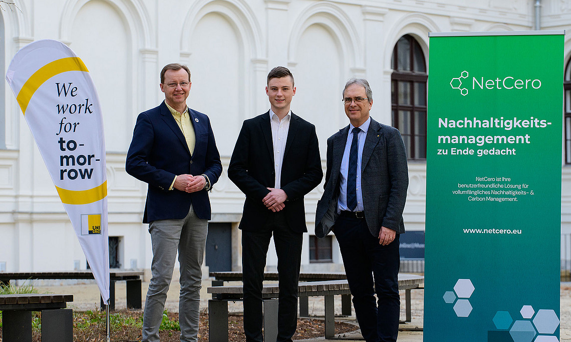 Gottfried Kirchengast, Lukas Windisch und Peter Riedler mit Uni-Graz-Beachflag und NetCero-Roll-up im Innenhof des Uni-Graz-Hauptgebäudes
