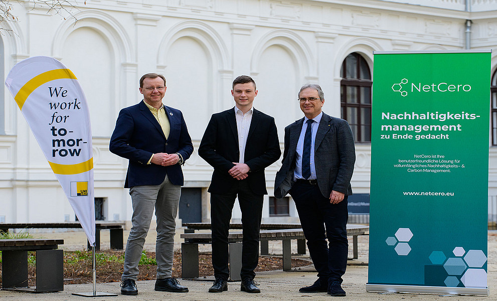 Gottfried Kirchengast, Lukas Windisch und Peter Riedler mit Uni-Graz-Beachflag und NetCero-Roll-up im Innenhof des Uni-Graz-Hauptgebäudes