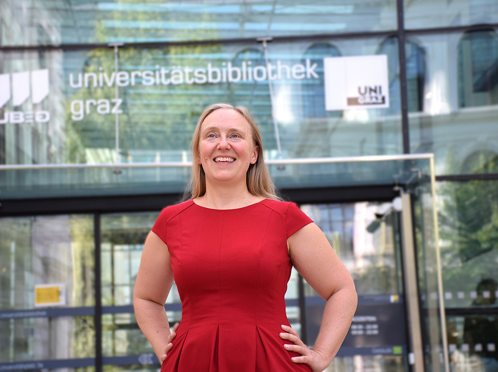 Portrait von Anouschk Foltz in einem roten Kleid vor der UB der Uni Graz ©Ulrike Freitag, Uni Graz
