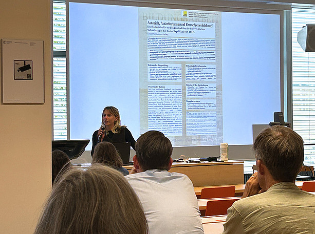 eine Frau steht vor einer Leinwand und hält eine Präsentation, im Publikum sitzen viele Menschen und hören zu ©Uni Graz/Freidorfer