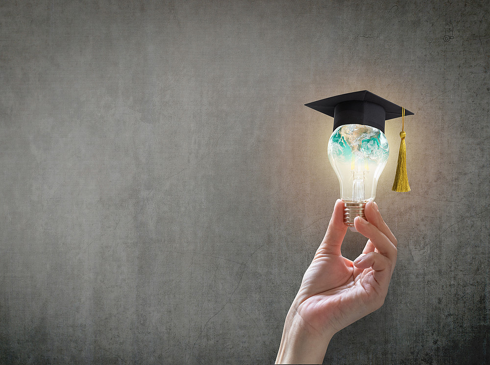 A glowing light bulb held by a hand and wearing a graduation hat (symbolic image) ©Chinnapong -stock.adobe.com