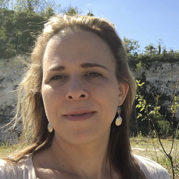 Das Bild zeigt Yvonne Živković, eine Frau, die wahrscheinlich ein Selfie macht. Sie hat blonde Haare und trägt Ohrringe. Im Hintergrund sind Bäume und ein steiler Felsen zu sehen, was darauf hindeutet, dass sie sich in der Natur befindet. Der Himmel ist blau, was auf einen sonnigen Tag hindeutet. ©Yvonne Živković