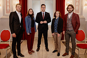 Group photo of the winners of the 2025 Sports Science Awards with Member of Parliament Gerhard Hirschmann in the centre in the ballroom of the Meerscheinschlössl