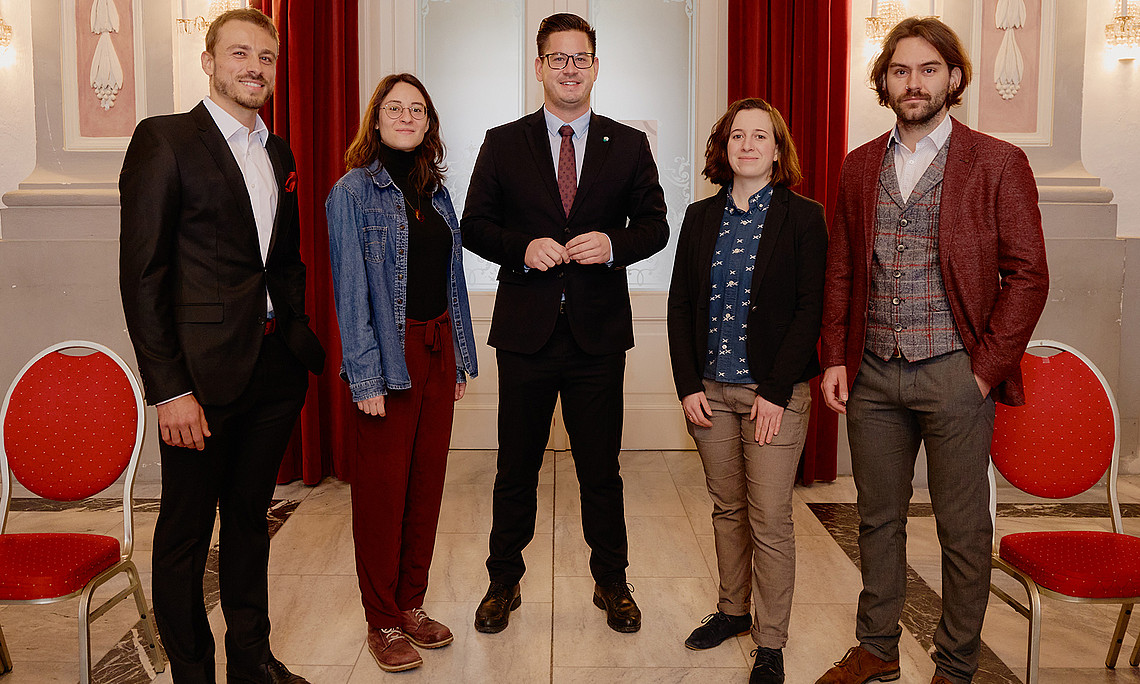 Group photo of the winners of the 2025 Sports Science Awards with Member of Parliament Gerhard Hirschmann in the centre in the ballroom of the Meerscheinschlössl