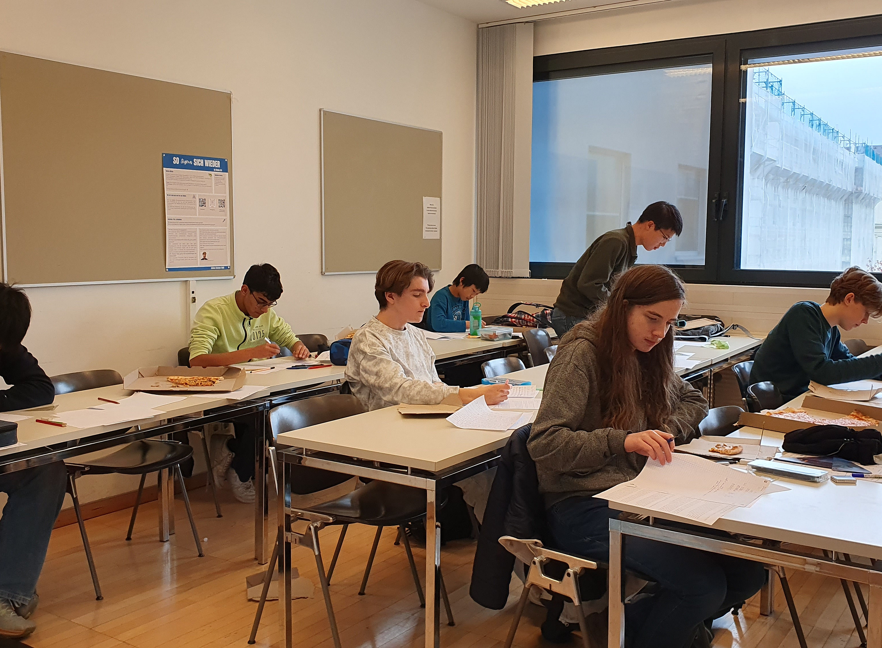 Seminarraum, in dem die tilnehmenden Schüler na ihren aufgaben tüfteln 