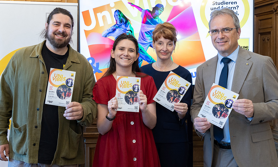 Vier Personen stehen nebeneinander und halten jeweils einen Flyer in der Hand.