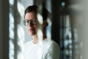 Portrait of Heike Karge photographed through a pane of glass