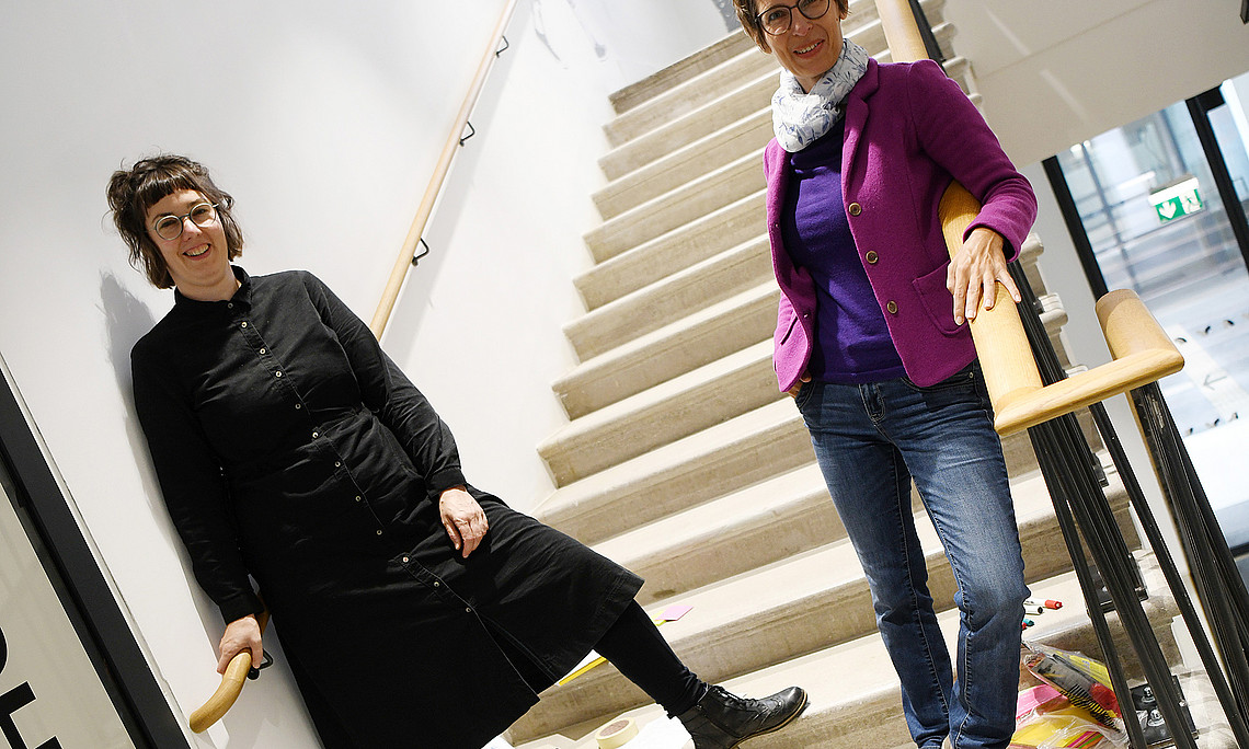Johanna Stadlbauer and Sabine Bergner at the foot of a staircase, photographed at an angle