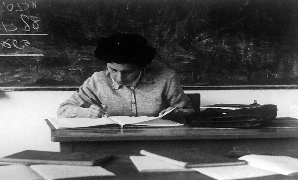 Trude Lang schreibend am Schreibtisch