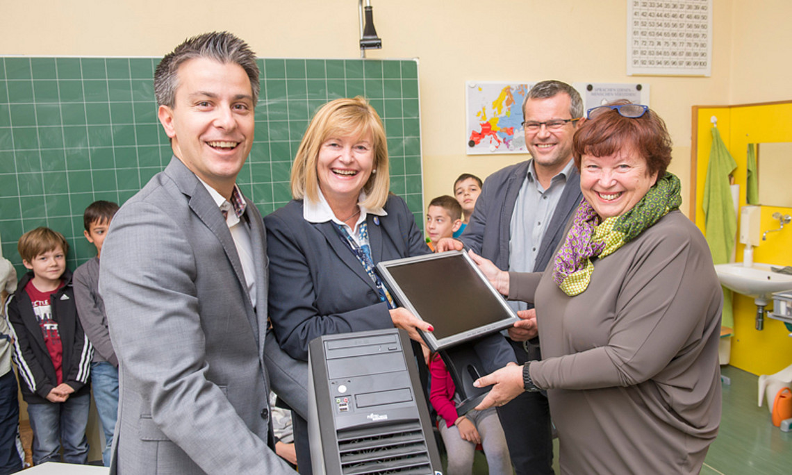 Stadtrat Kurt Hohensinner, Rektorin Christa Neuper und Wolfgang Skof, Leiter des Referats Technisches Management Schulen der Stadt Graz (v.l.), übergaben Heidi Scheucher, Direktorin der VS Geidorf (ganz rechts), insgesamt fünf Computer. Foto: Stadt Graz