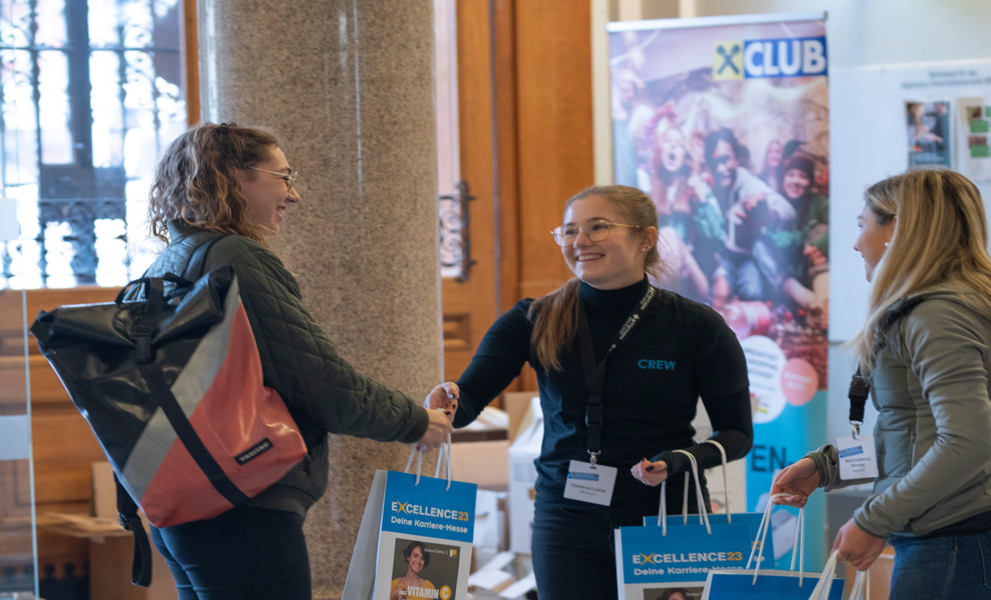 EXCELLENCE23 Besucherin wird beim Eingang der Karrieremesse der Uni Graz mit einem Goodie-Bag empfangen. Foto: Uni Graz/Angele