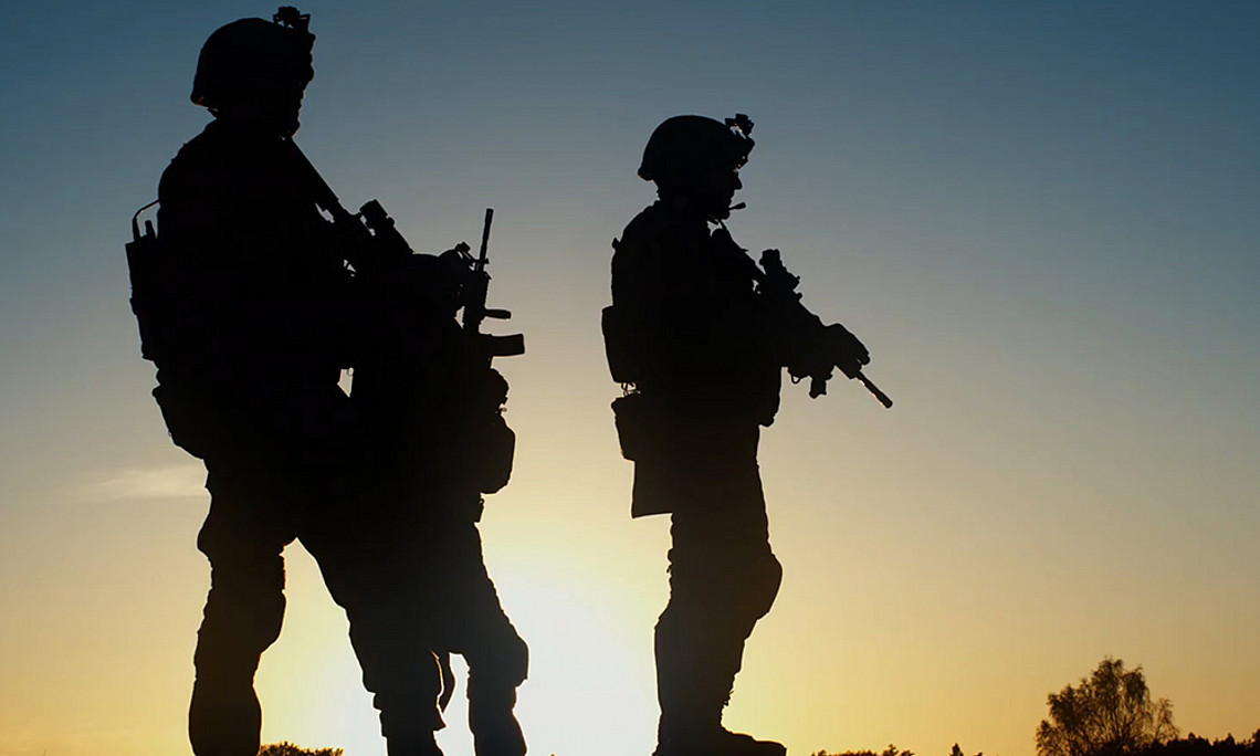 Soldiers with gun at dawn