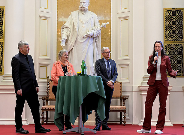 Karl Steininger, Daniela Jacob, Thomas Hlatky, Nina Knittel around a bar table on the podium in the auditorium, behind them the statue of the emperor. ©CP-PICTURES