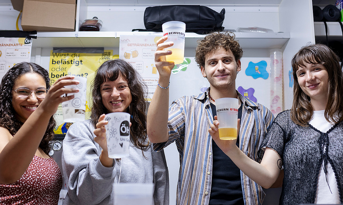 Four young people raising their cups at the Uni vibes festival