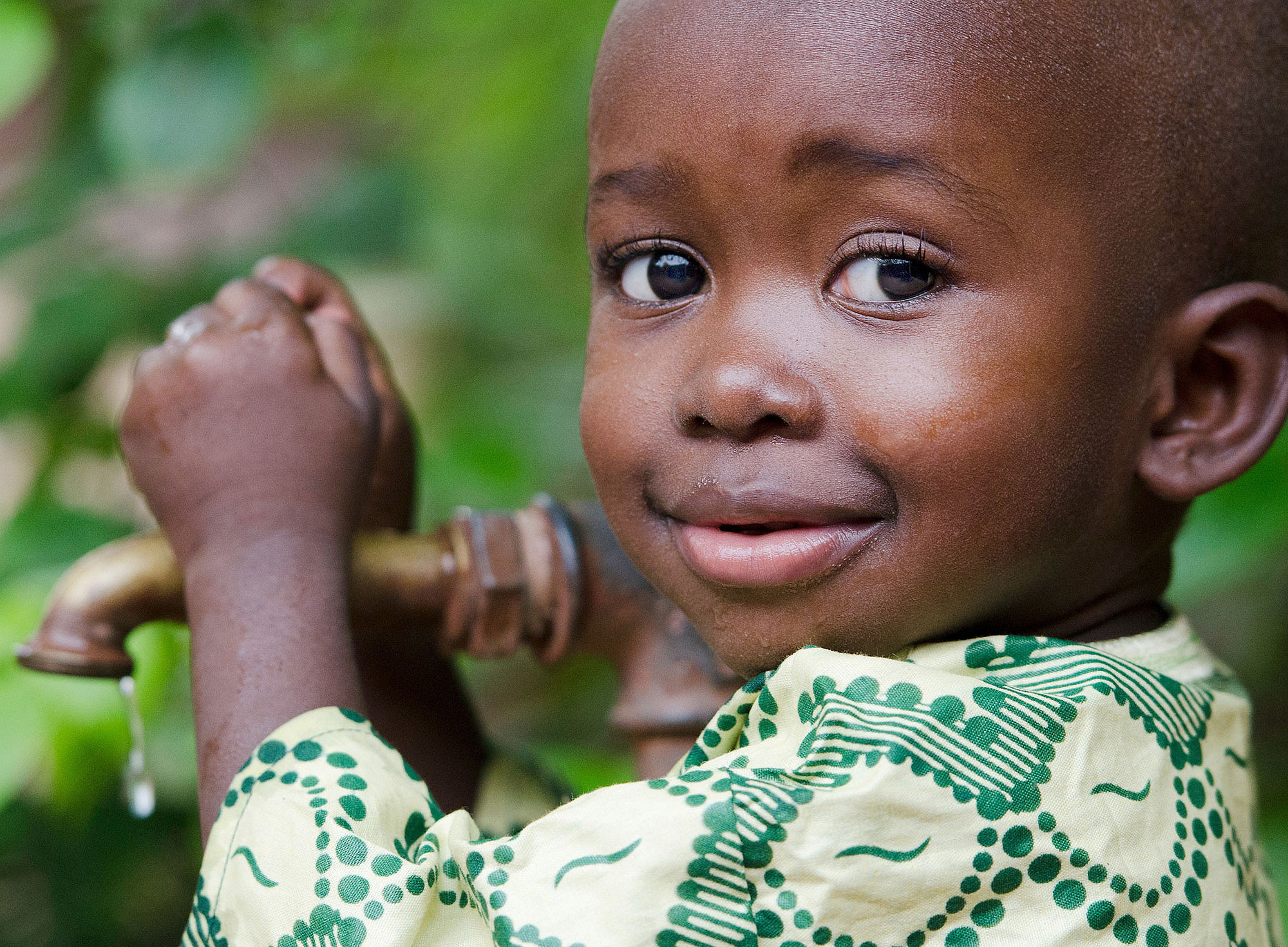 kleiner afrikanischer Bub umfasst einen Wasserhahn ©Mayer Riccardo - stock.adobe.com