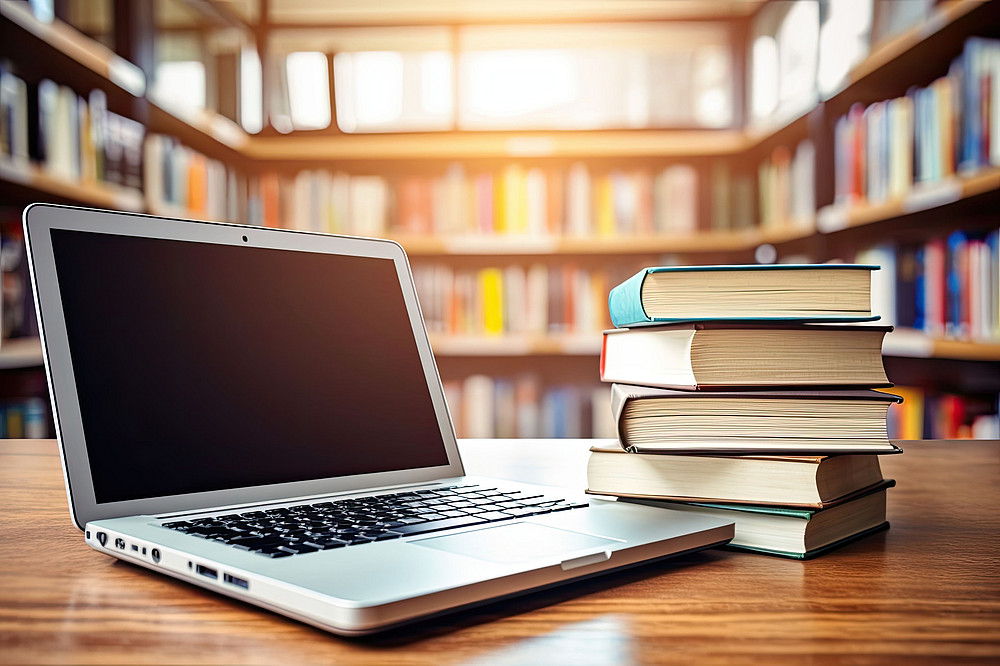 Laptop auf Tisch, daneben Bücher ©Marat - stock.adobe.com