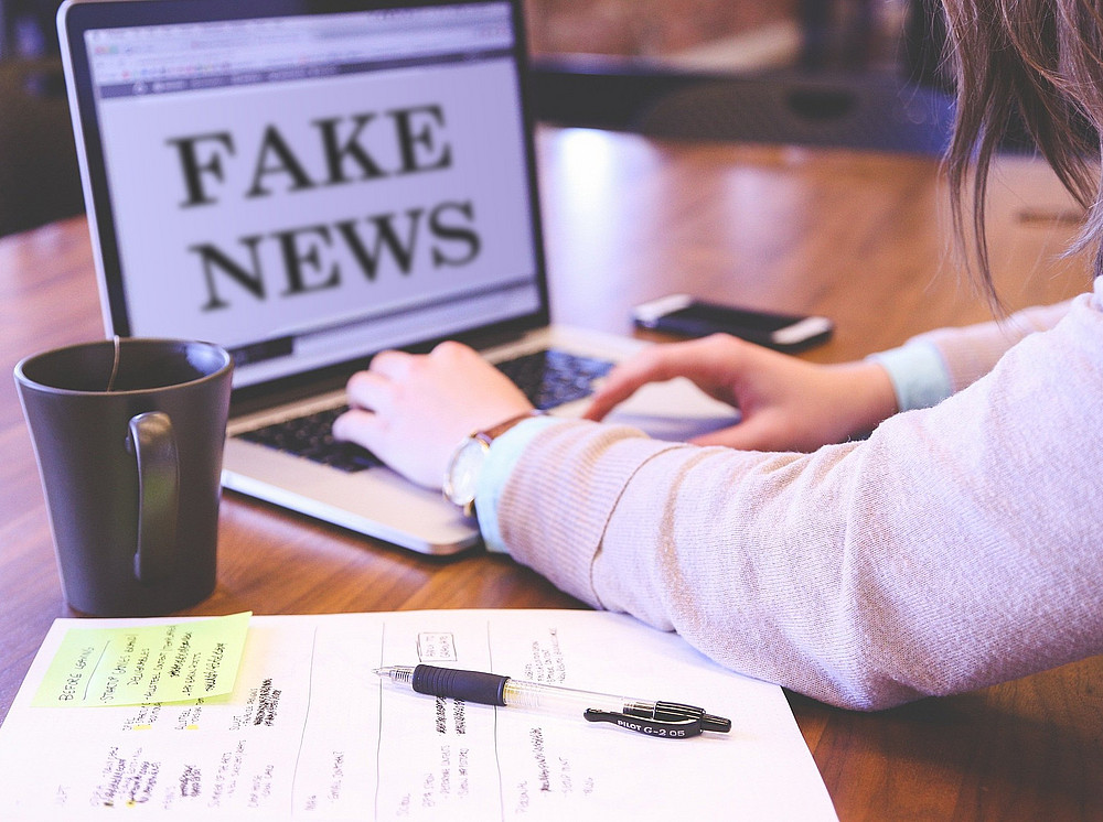 Zwei Arme tippen am Laptop, auf dessen Bildschirm "Fake News" zu lesen ist ©Pixabay/memyselfaneye