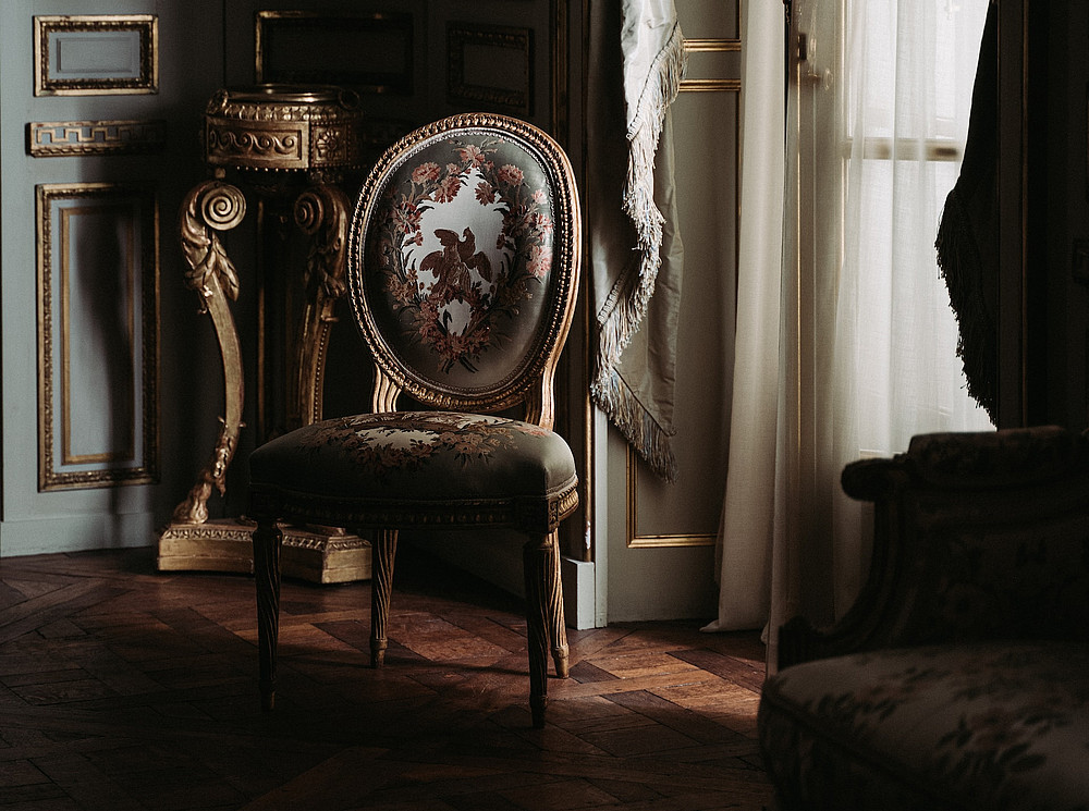 Ein antiker Stuhl in einem abdunkelnden Raum ©ZHENYU LUO