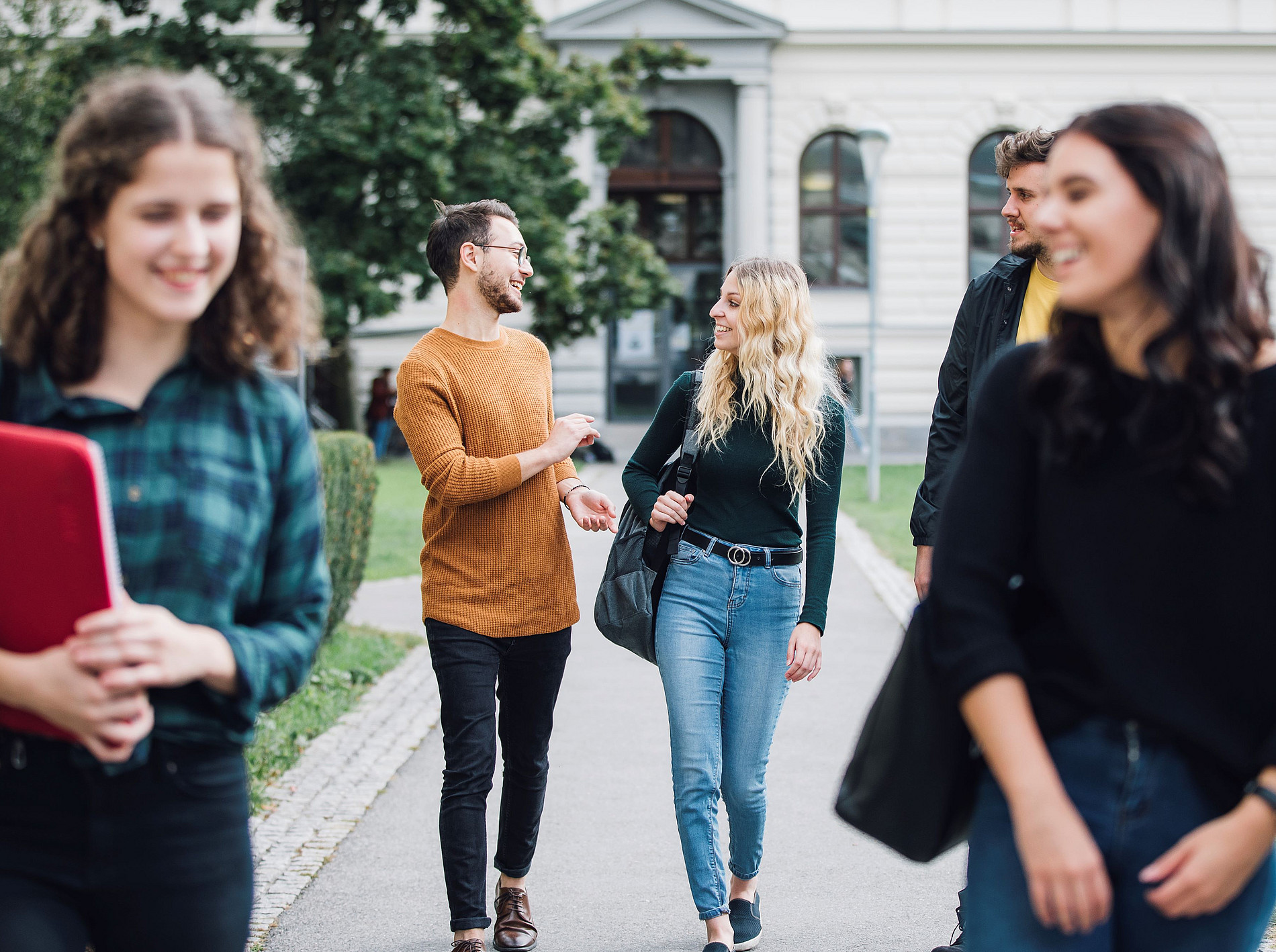 Das Bild zeigt eine Gruppe Studierender die am Campus gehen und sich miteinander unterhalten. ©Uni Graz / Kanizaj 