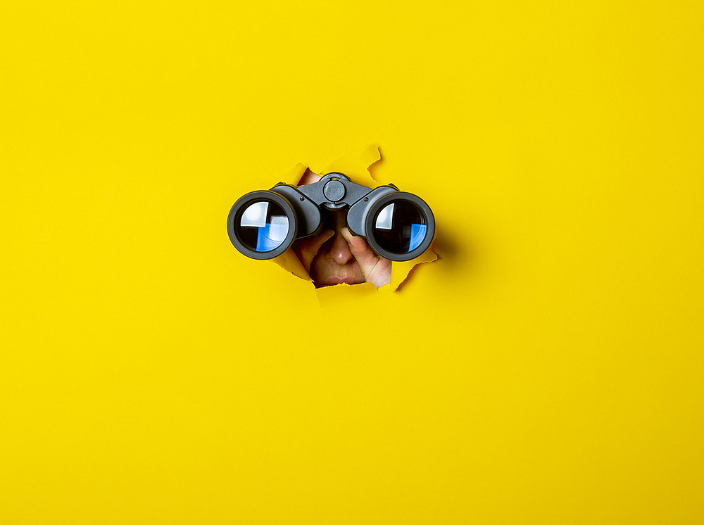 Binoculars against a yellow background ©Alex - stock.adobe.com
