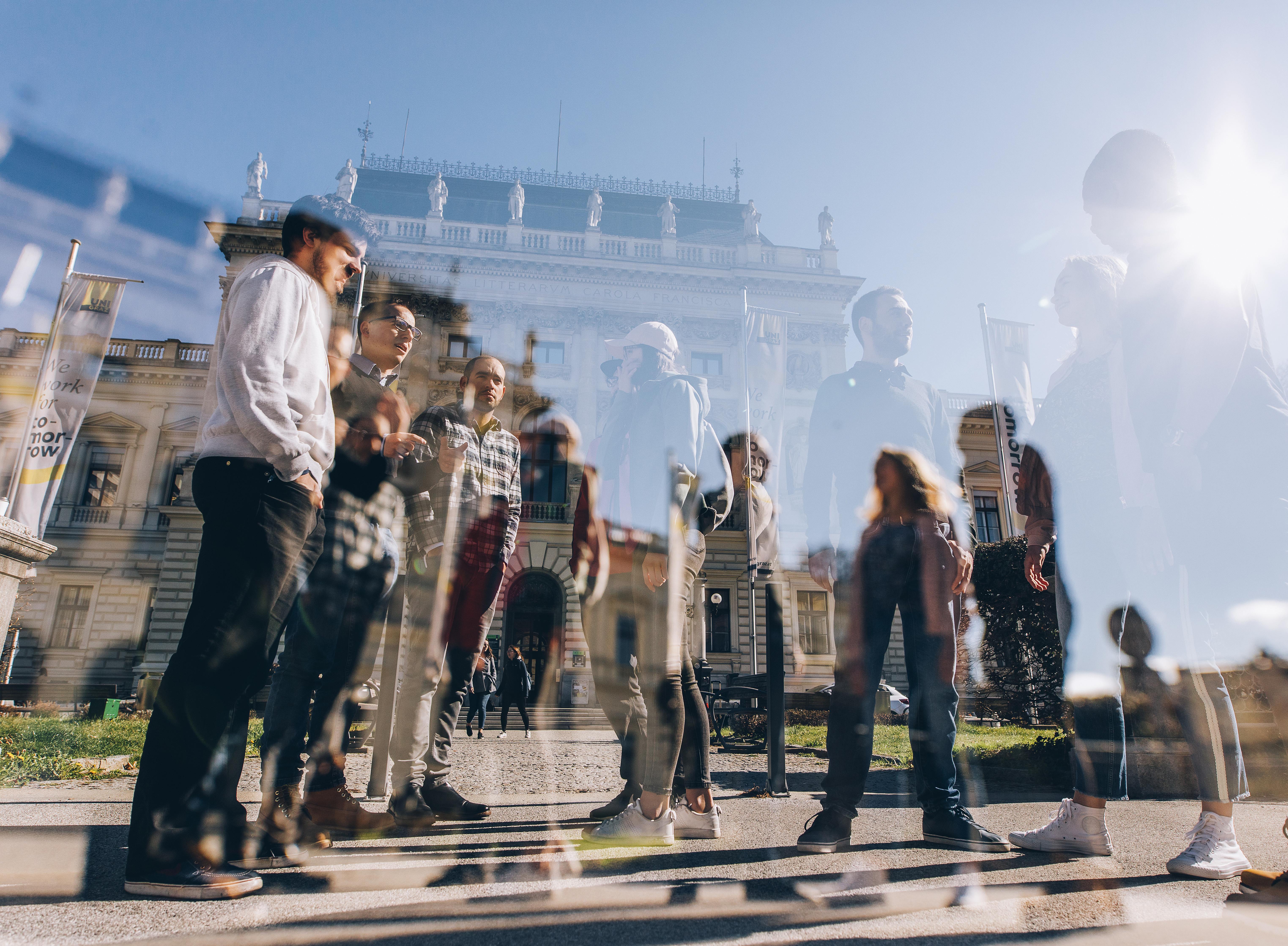 kleine Gruppe von Menschen vor dem Hauptgebäude der Uni Graz ©Uni Graz/Kanizaj